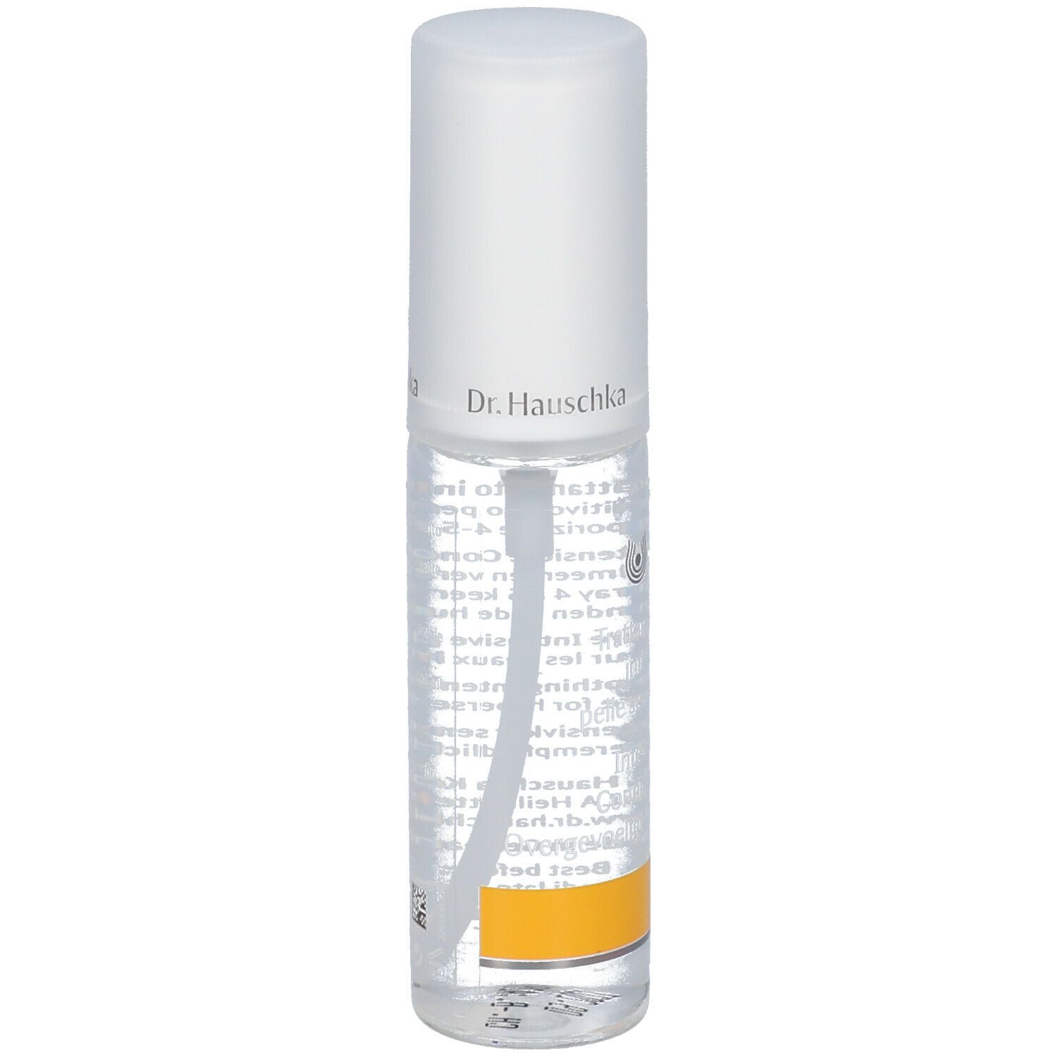 Flacone trasparente con erogatore spray. Scritta: Dr. Hauschka. Etichetta con testo. Striscia gialla in basso.