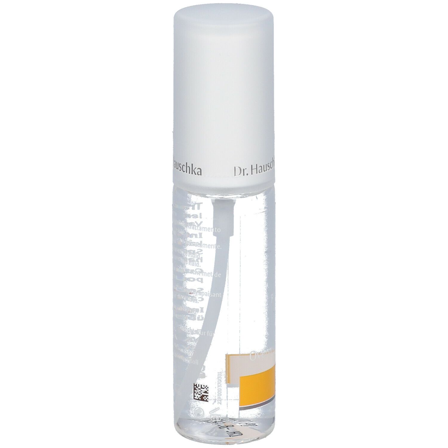 Flacone trasparente con erogatore spray. Scritta: Dr. Hauschka. Etichetta con testo. Striscia gialla in basso.