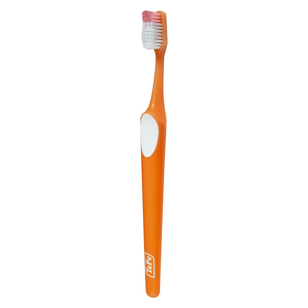 Spazzolino TePe Nova, manico arancione, testina bianca. Setole bianche. Design ergonomico.