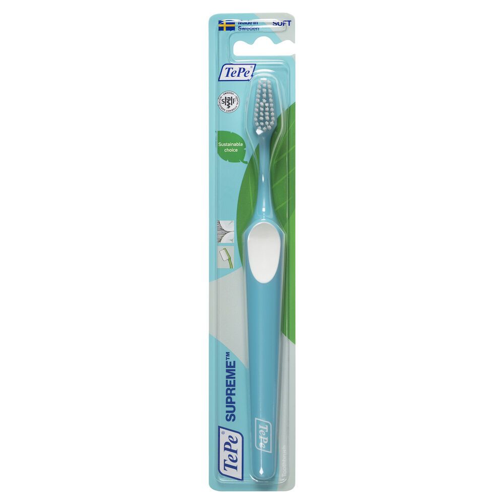 Spazzolino TePe Supreme azzurro chiaro, confezionato. Manico con inserto bianco. Setole grigie. Confezione con logo e nome del prodotto.