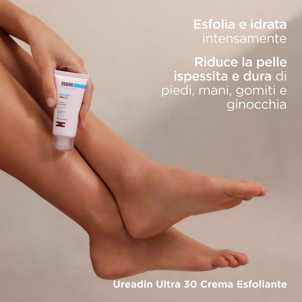 Persona che tiene ISDIN Ureadin Ultra 30 crema. Piedi in primo piano. Testo: Ureadin Ultra 30 Crema Esfoliante.