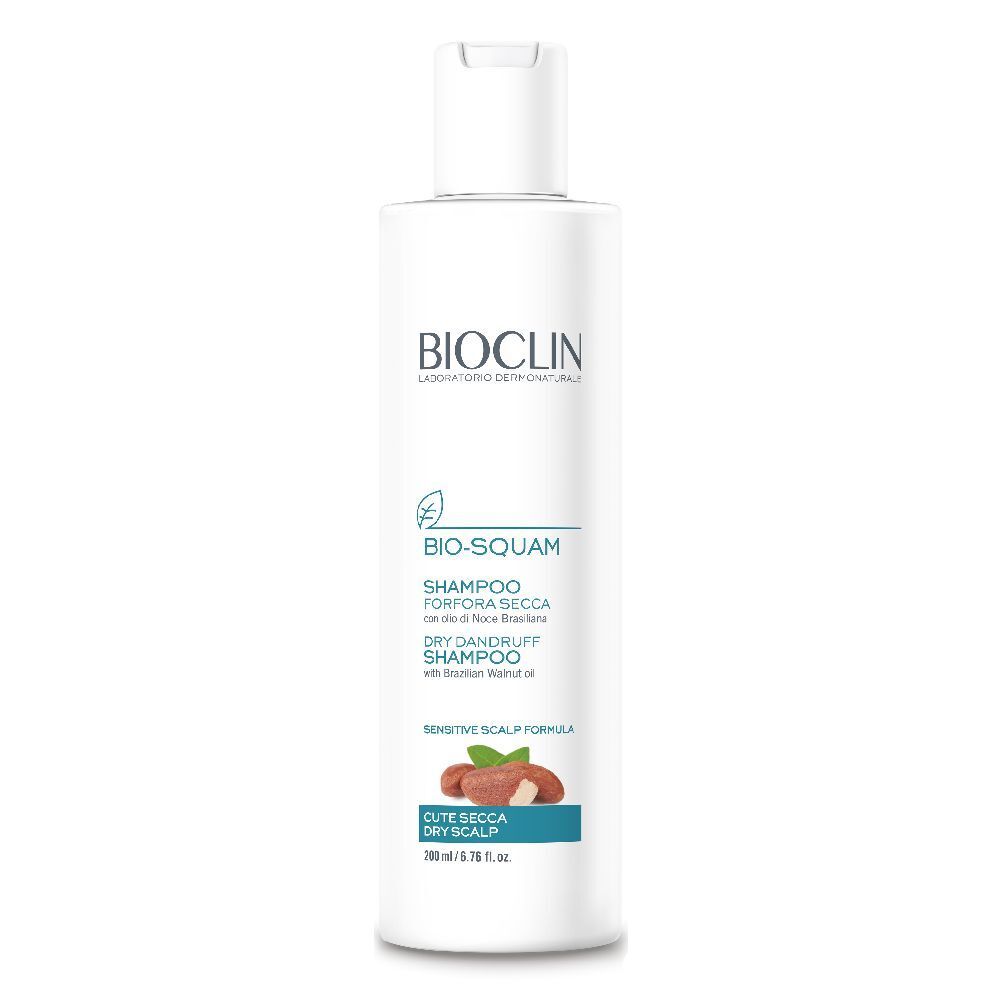 Flacone bianco BIOCLIN Bio-Squam Shampoo. Testo: Shampoo per forfora secca. Illustrazione: noce e foglia.
