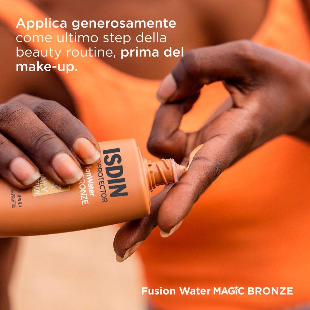Frau trägt Sonnencreme auf. ISDIN, Fusion Water, Magic Bronze. Anwendung als letzter Schritt vor dem Make-up.