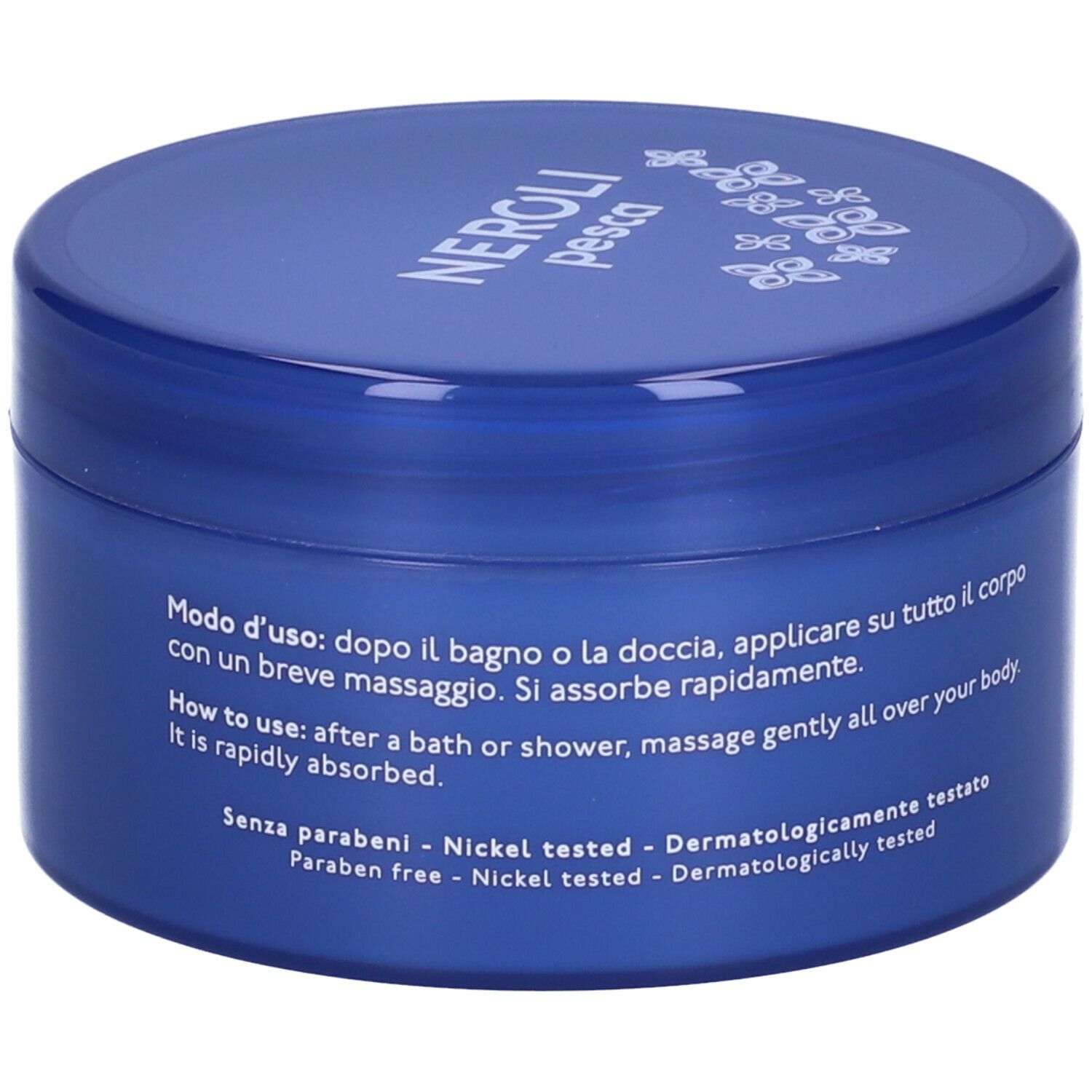 Vaso blu con scritte bianche. Testo: Modo d'uso: Massaggiare delicatamente dopo la doccia. Senza parabeni.