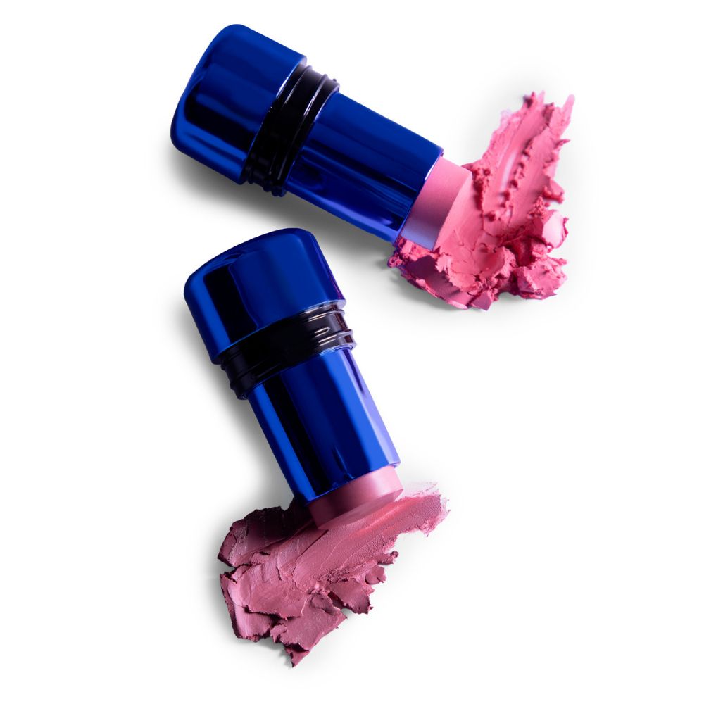 Due stick blu con prodotto cremoso rosa e campioni.
