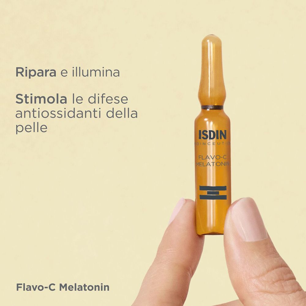 Mano che tiene una fiala ambrata. Scritta: ISDIN, Flavo-C Melatonin. Testo: Ripara e illumina.