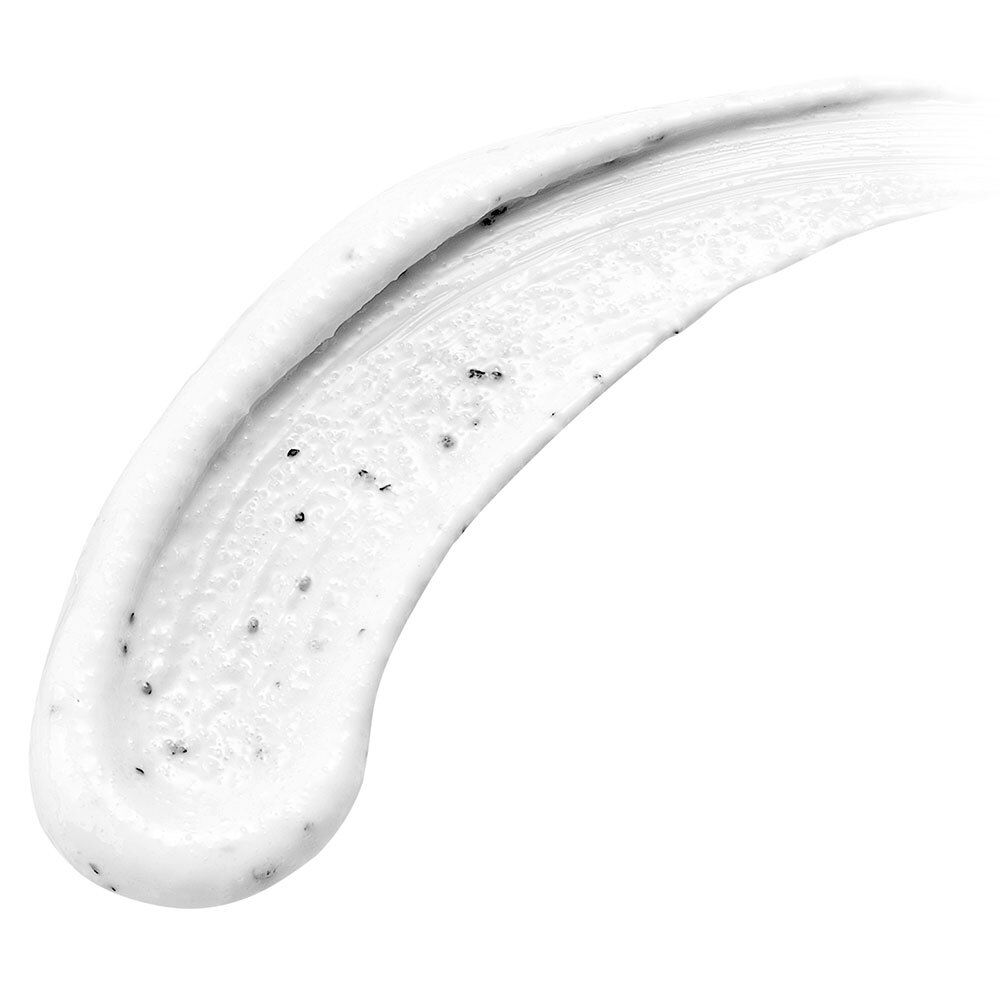 Crème blanche avec particules foncées, appliquée en une ligne incurvée. Texture visible.