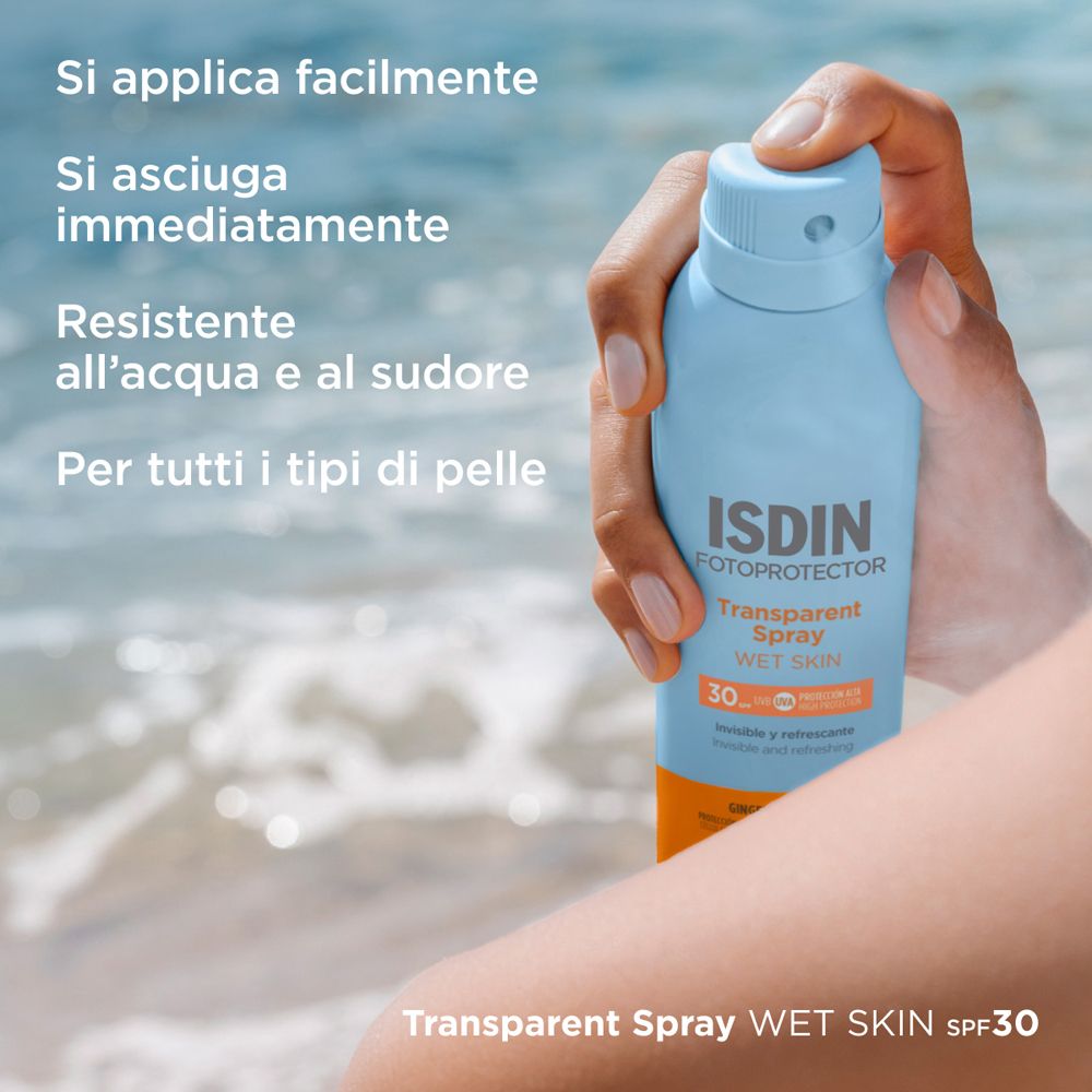 Person hält eine blaue Sprühflasche. ISDIN Fotoprotector Transparent Spray Wet Skin SPF30. Text: Einfache Anwendung, schnell trocknend.