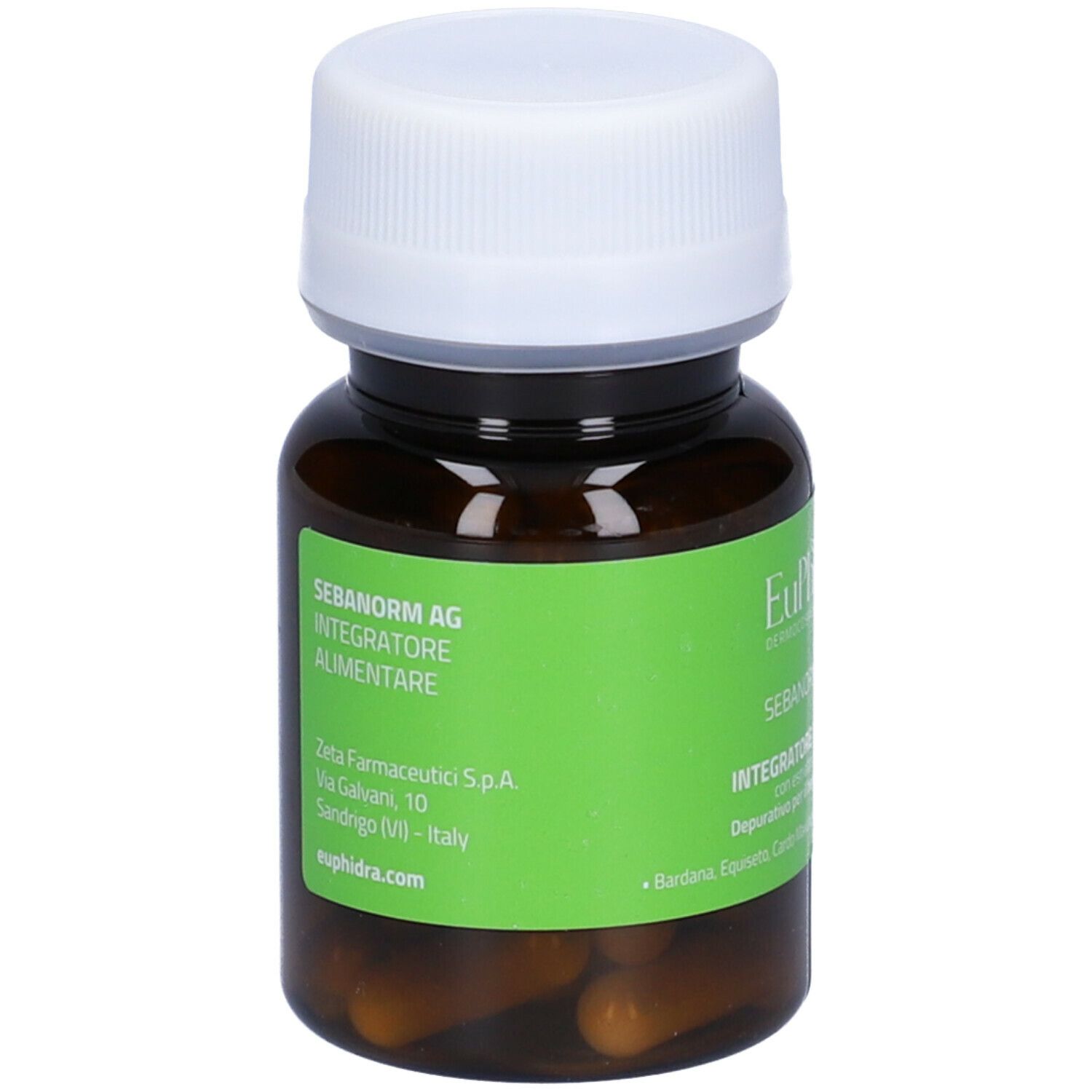 Flacone marrone con tappo bianco. Etichetta verde con nome prodotto e indirizzo produttore. Capsule visibili.