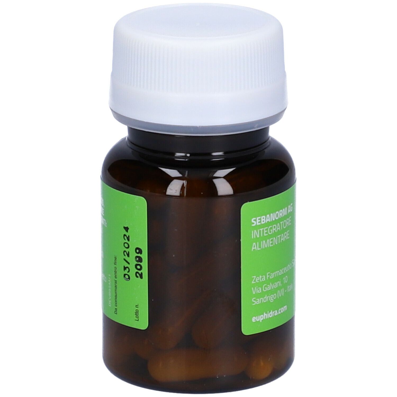 Flacone marrone con tappo bianco. Etichetta verde con nome prodotto e data di scadenza. Capsule visibili.