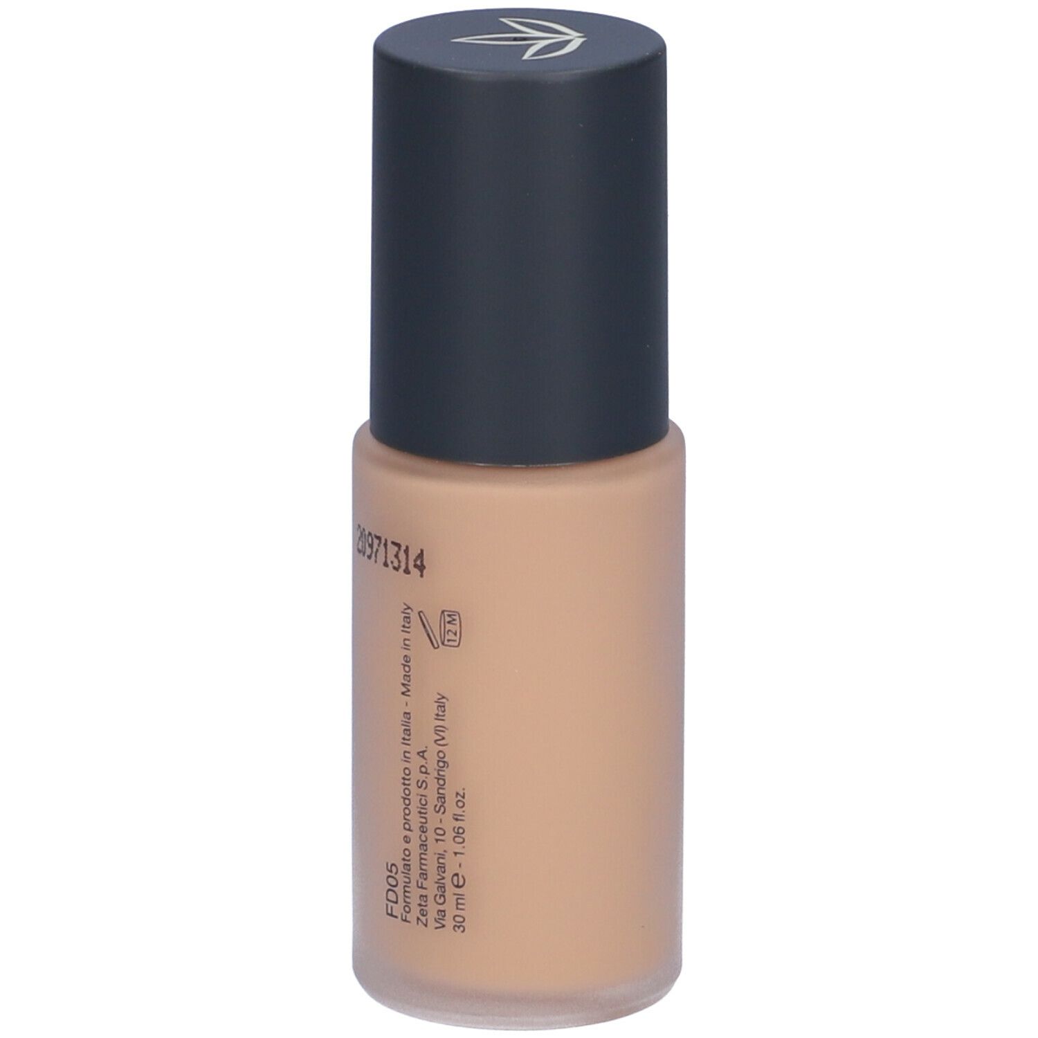 Fondotinta beige in flacone cilindrico con tappo nero. Scritta e dettagli di produzione.