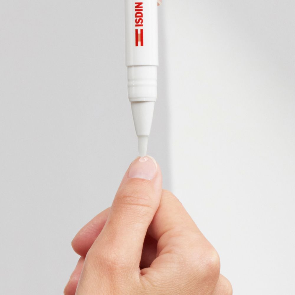 ISDIN Si-Nails Micoxpert MD. Tubo bianco con applicatore. Applicazione su un'unghia. Primo piano.