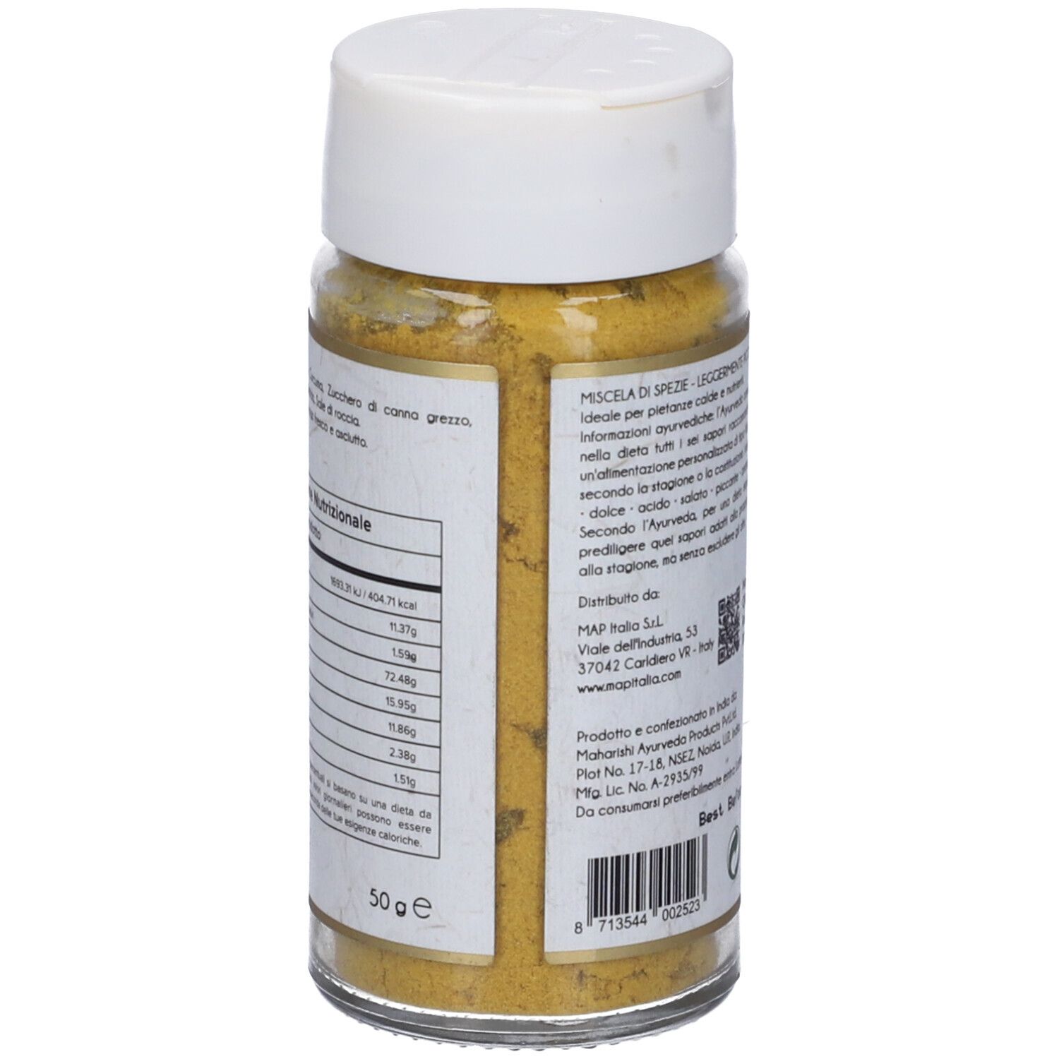 Rückseite des Glasbehälters mit gelbem Inhalt. Text. Aufschrift: Maharishi Ayurveda, Vata Churna, Miscela di spezie, 50 g.