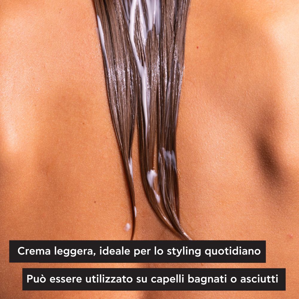 Vista posteriore di una persona. Una crema viene applicata sui capelli. Testo: Crema leggera, ideale per lo styling quotidiano.