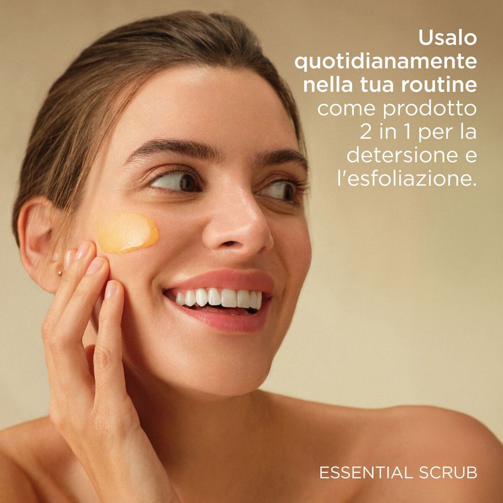 Frau berührt ihr Gesicht. Text: Usalo quotidianamente nella tua routine come prodotto 2 in 1 per la detersione e l'esfoliazione.