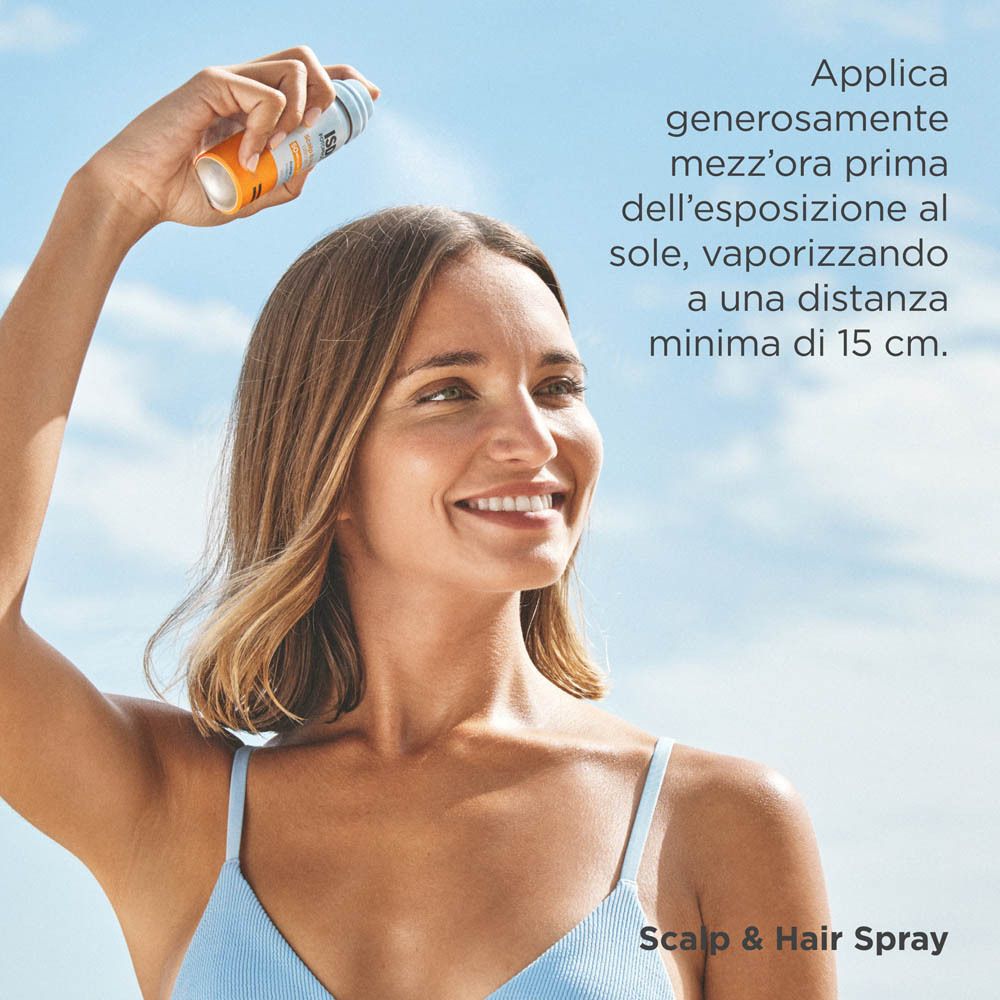 Donna che spruzza Isdin Scalp & Hair Spray SPF50 su cuoio capelluto e capelli.