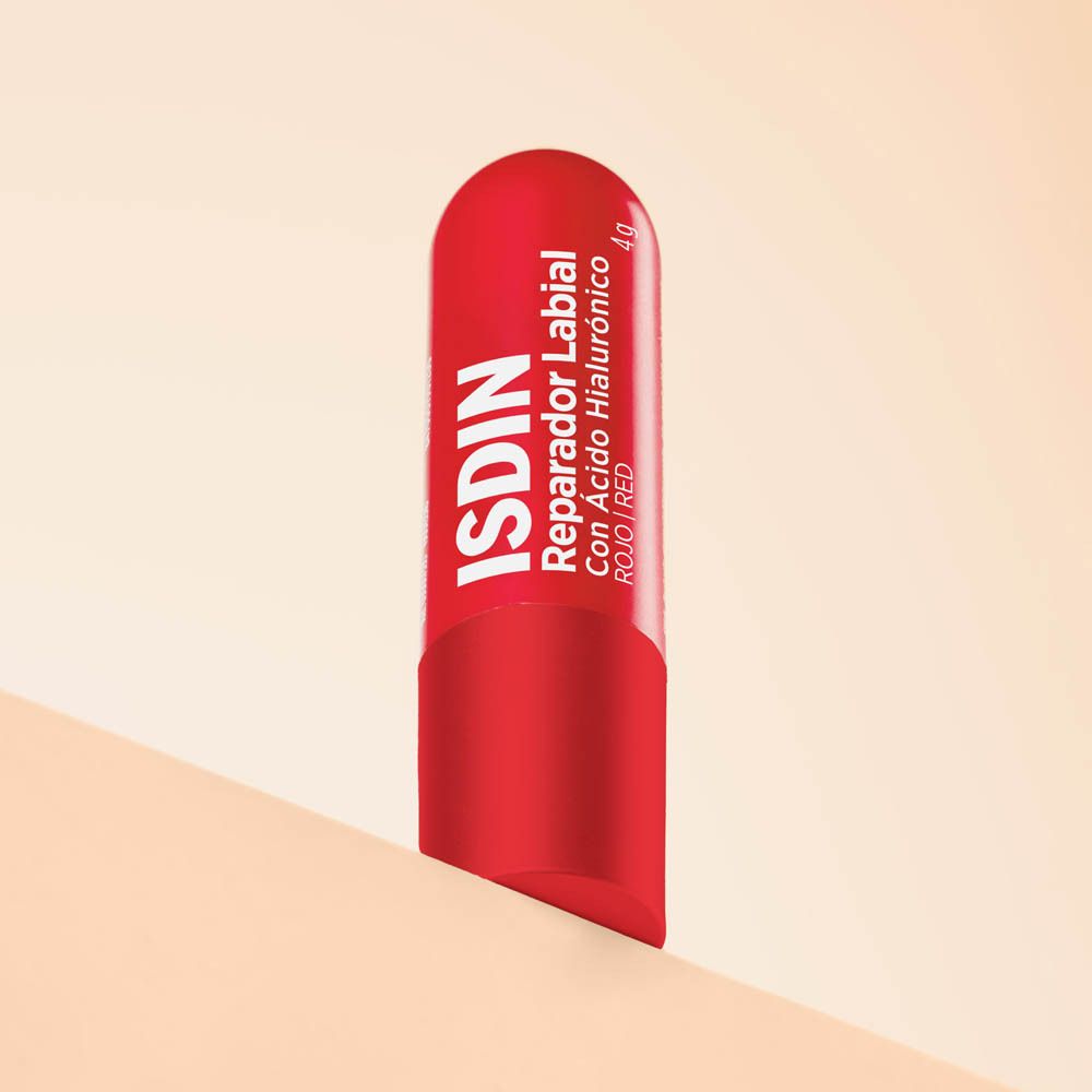 Roter Lippenpflegestift. ISDIN Reparador Labial. Auf einer Oberfläche.