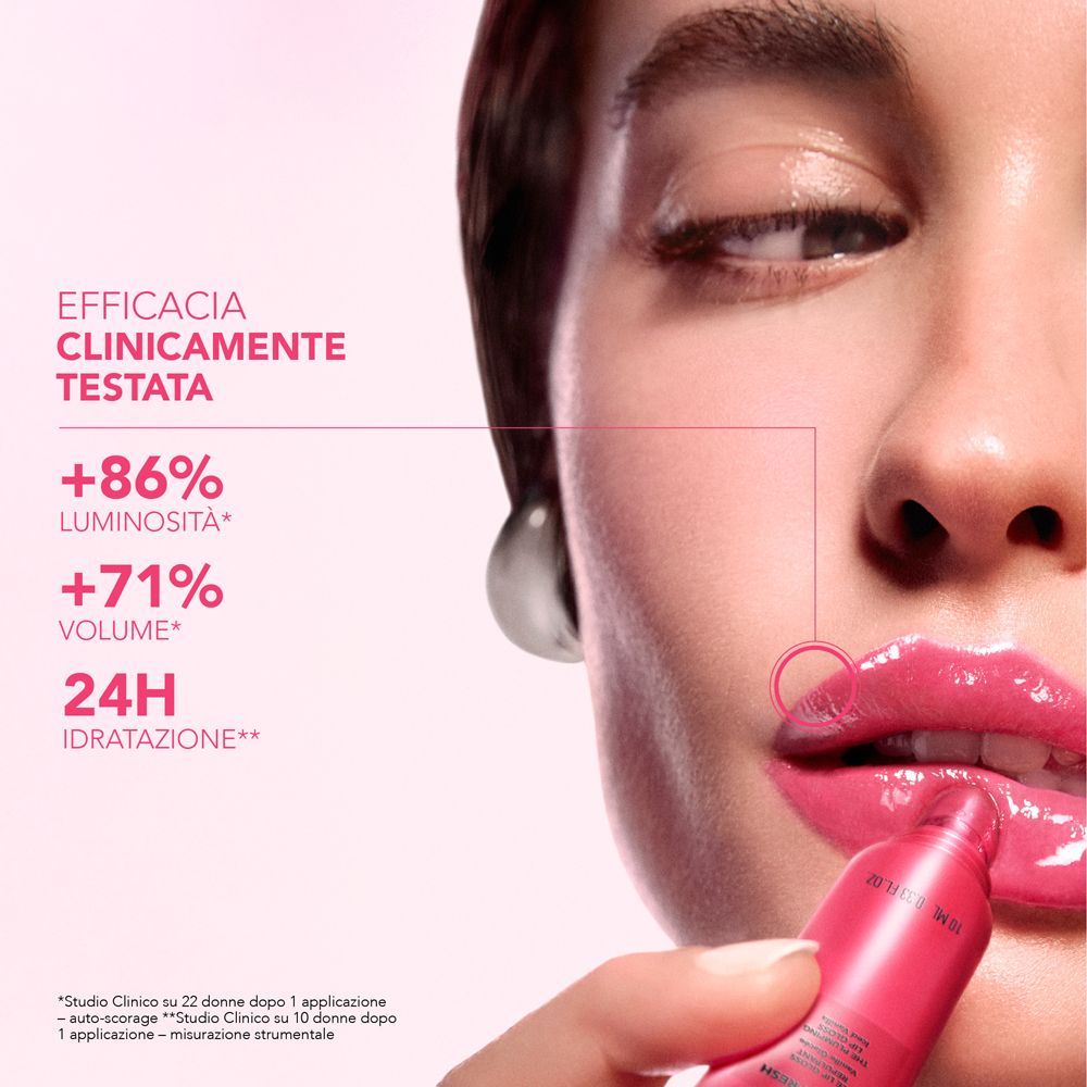 Donna con labbra lucide tiene un tubetto rosa di prodotto per labbra.