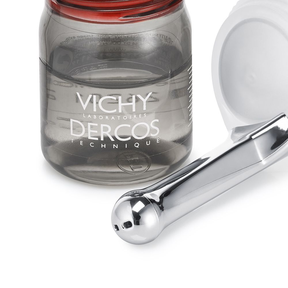 Primo piano di fiala e applicatore. Scritta: VICHY Dercos. Liquido trasparente. Applicatore bianco.
