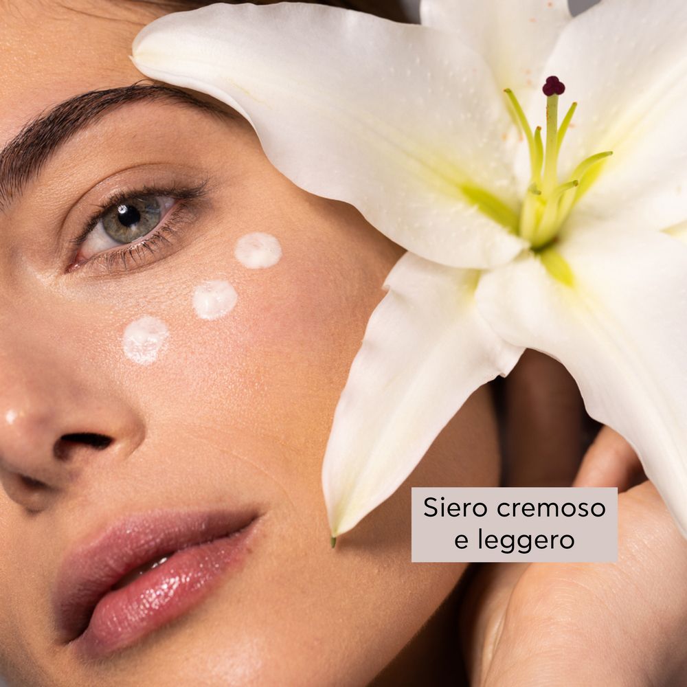 Donna con crema sulla pelle. Giglio bianco. Testo: Siero cremoso e leggero.