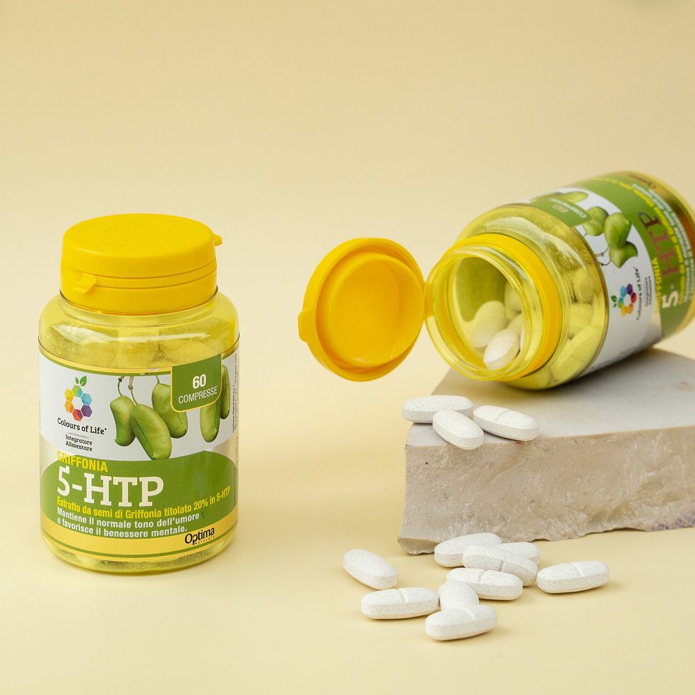 Zwei Behälter "Griffonia 5-HTP", einer geöffnet, mit herausfallenden Kapseln auf einem Steinpodest.