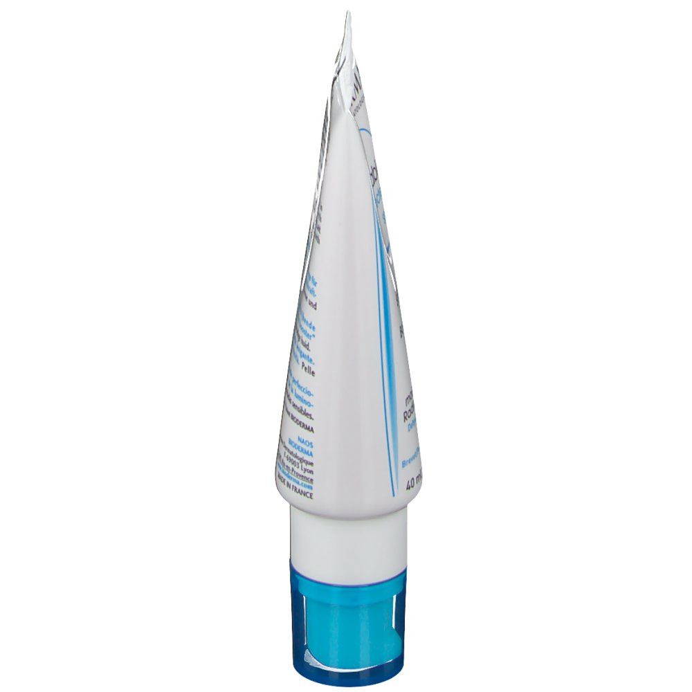 Vista laterale del tubo. Bianco con scritte blu e tappo. Testo in francese e inglese.