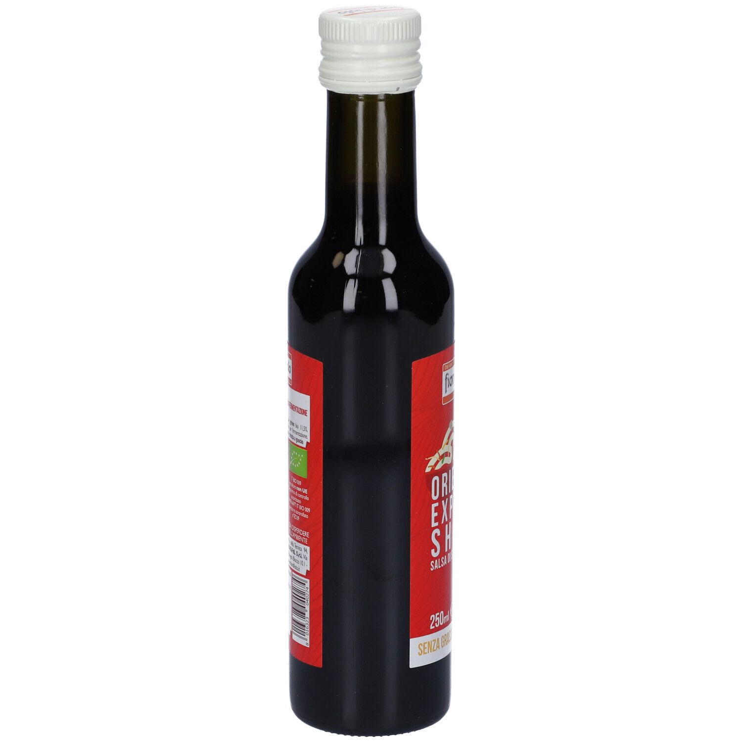 Piccola bottiglia di vetro con tappo bianco. Etichetta rossa con testo. Contiene liquido scuro. Vista laterale.