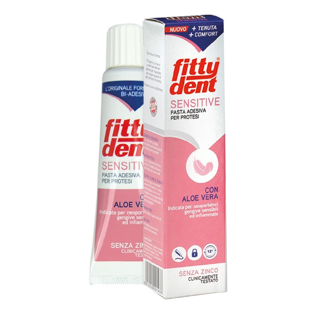 Tubo e scatola di dentifricio. Scritta: Fittydent Sensitive Pasta Adesiva, Aloe Vera. Confezione rosa e bianca.