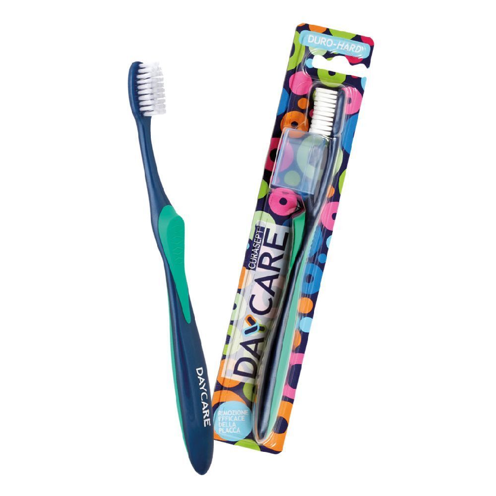 Spazzolino blu e verde, accanto alla confezione. Scritta DAYCARE e DURO-HARD.