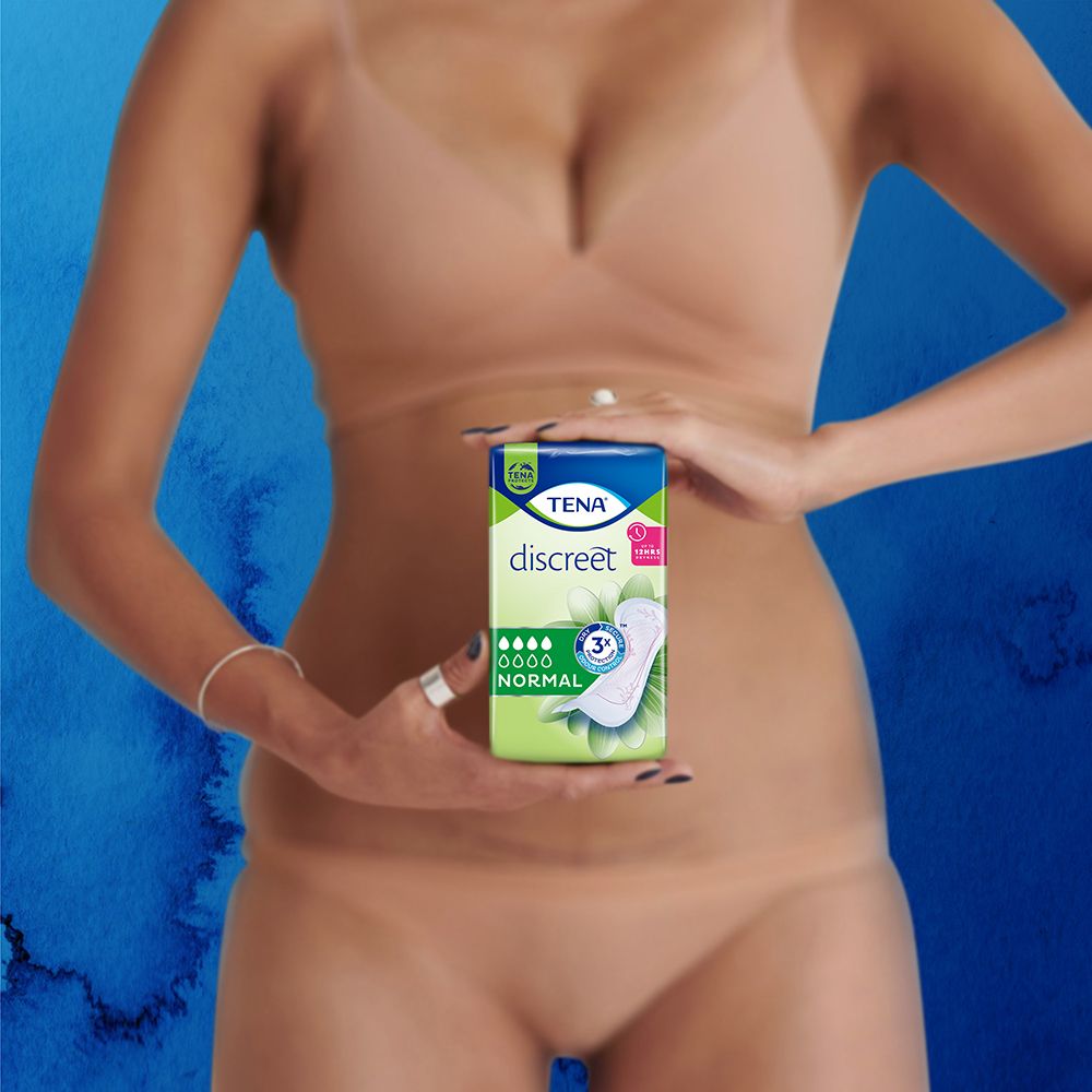 Frau hält eine Packung TENA Discreet Normal Slipeinlagen. Die Einlage ist teilweise abgewickelt.