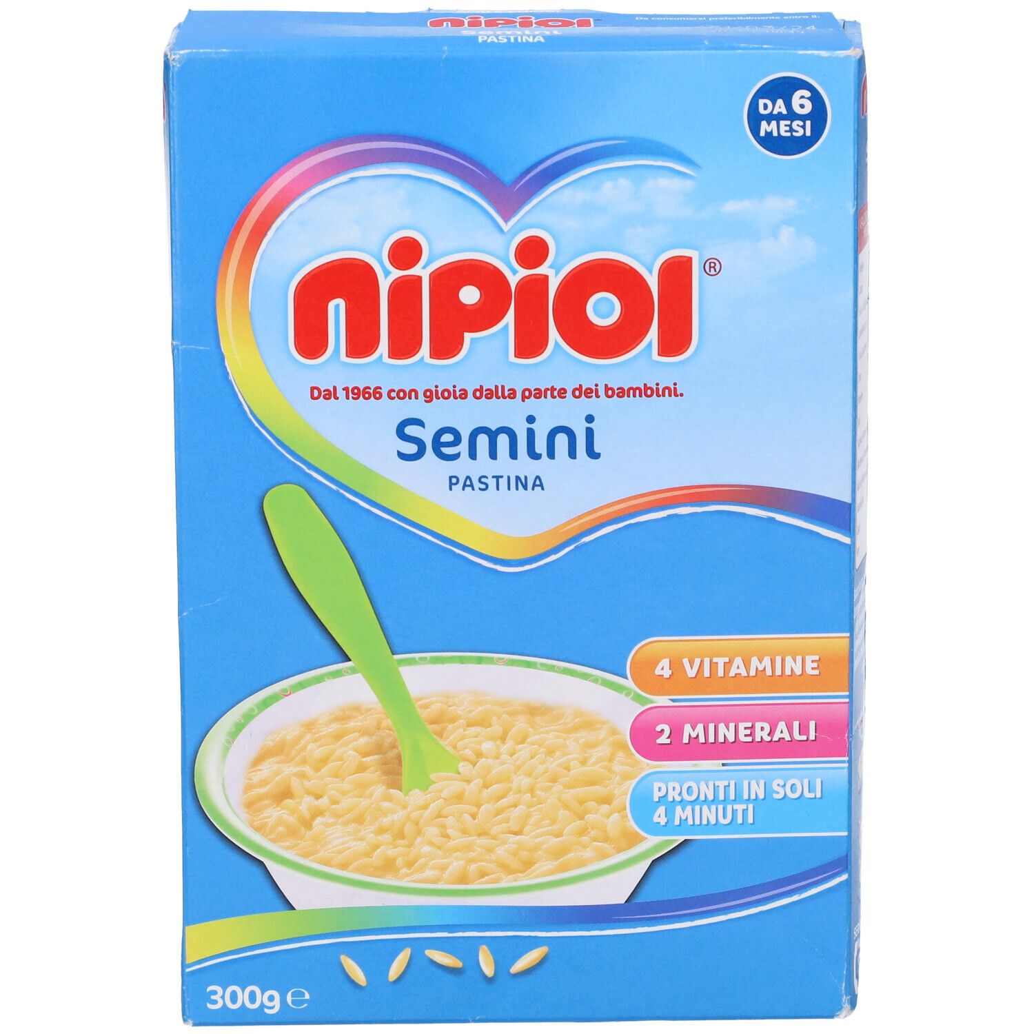 Confezione blu con immagine del prodotto. Contiene Pastina Semini. Scritte: Nipiol, Semini, 4 vitamine, 2 minerali, 300g.