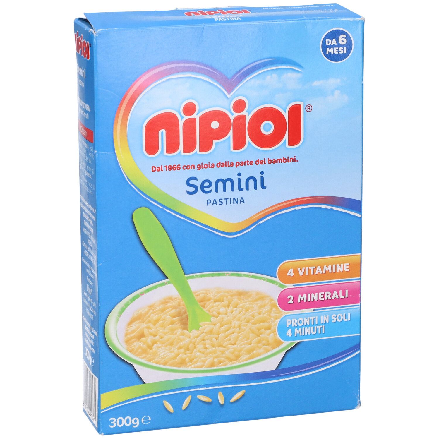 Confezione blu con immagine del prodotto. Contiene Pastina Semini. Scritte: Nipiol, Semini, 4 vitamine, 2 minerali, 300g.