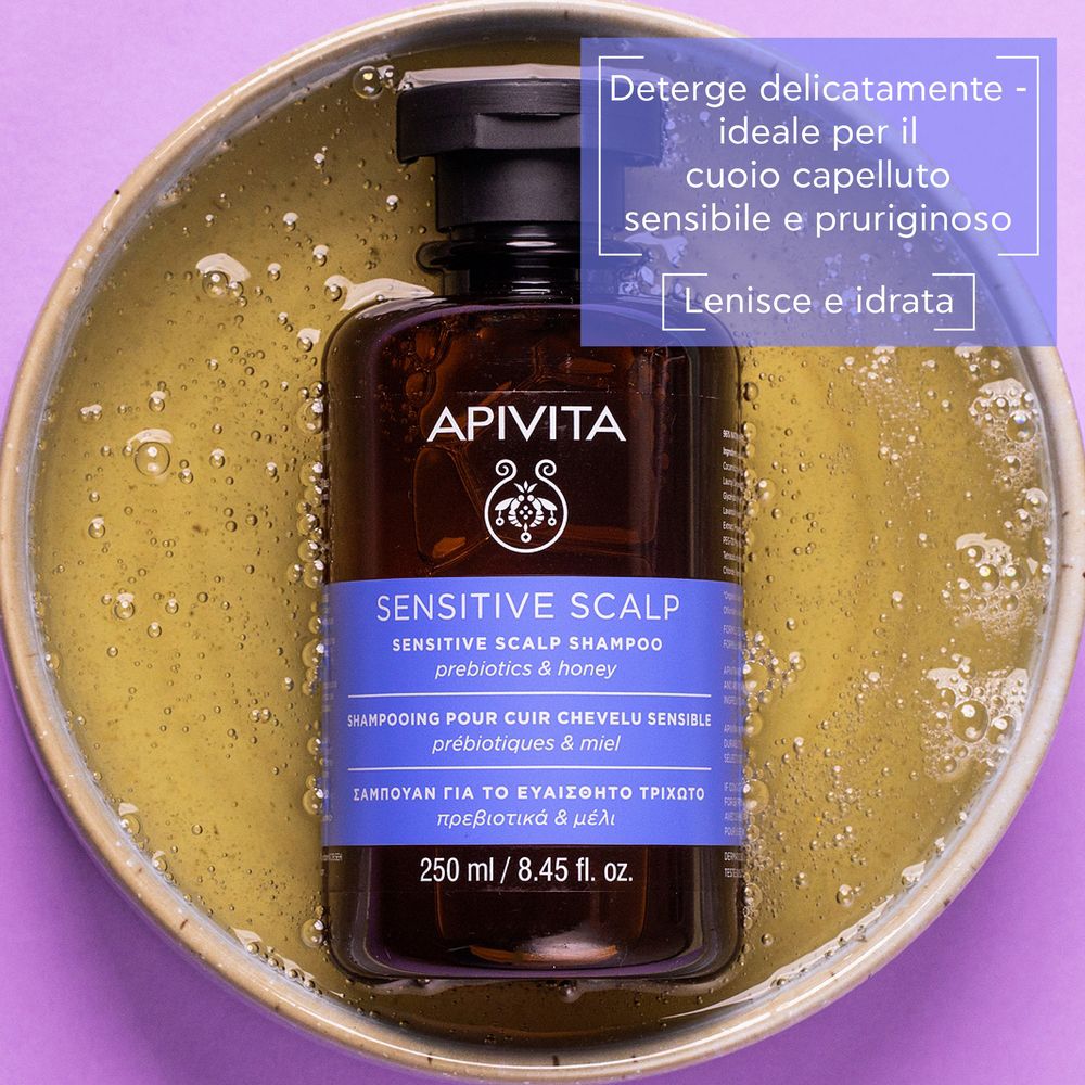 Flacone marrone in una ciotola con liquido. Scritta: APIVITA, Sensitive Scalp Shampoo, 250 ml.