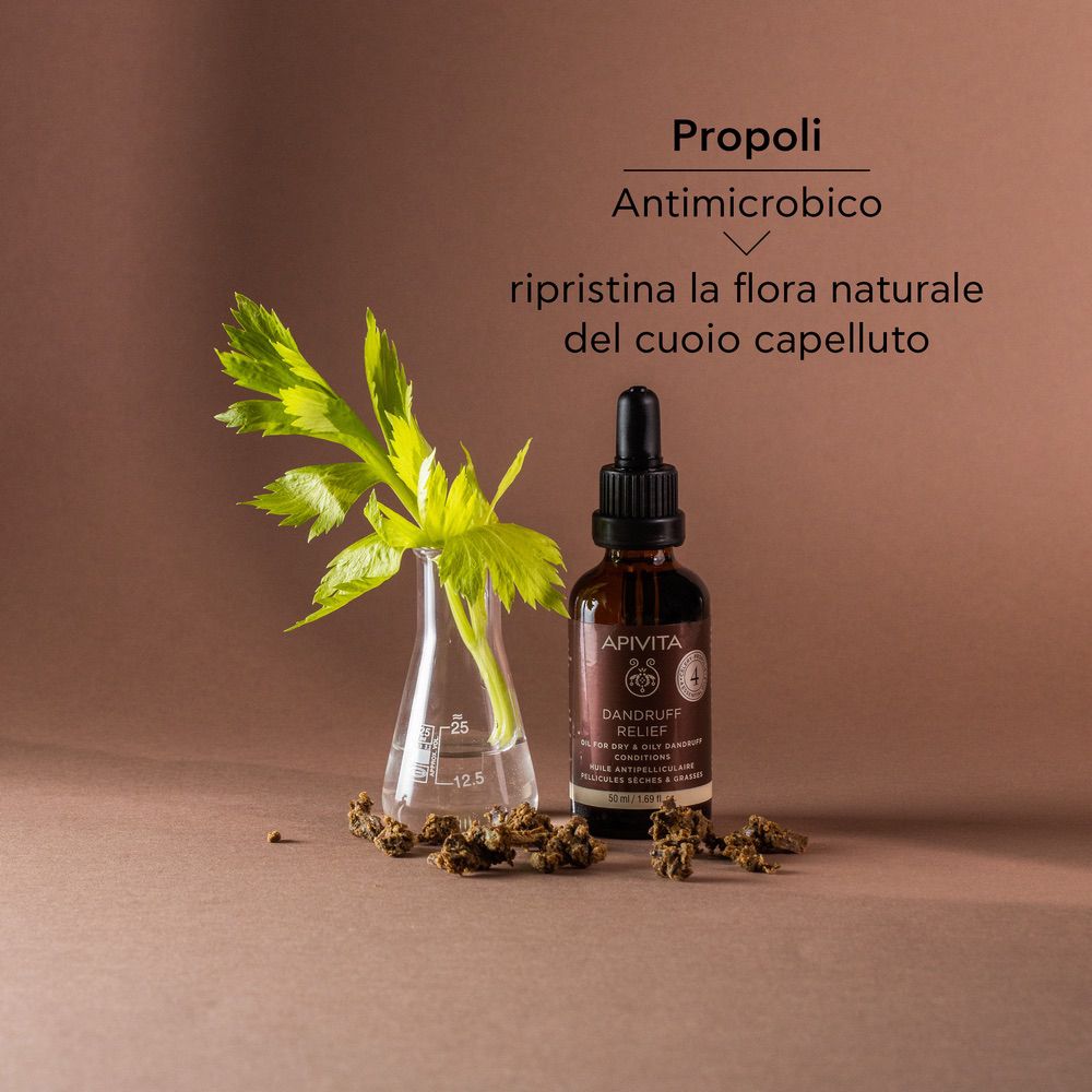 Flacone di prodotto con erbe. Scritta: APIVITA, DANDRUFF RELIEF. Testo: Propoli, Antimicrobico, ripristina la flora naturale del cuoio capelluto.