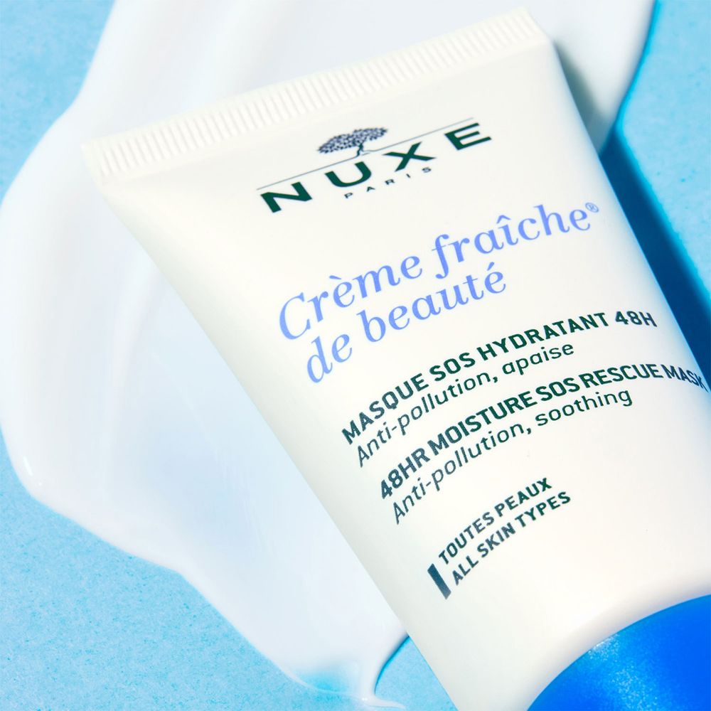 Tube blanc avec bouchon bleu et produit sur fond bleu. Inscription : Nuxe Paris, Crème fraîche de beauté, Masque SOS hydratant.