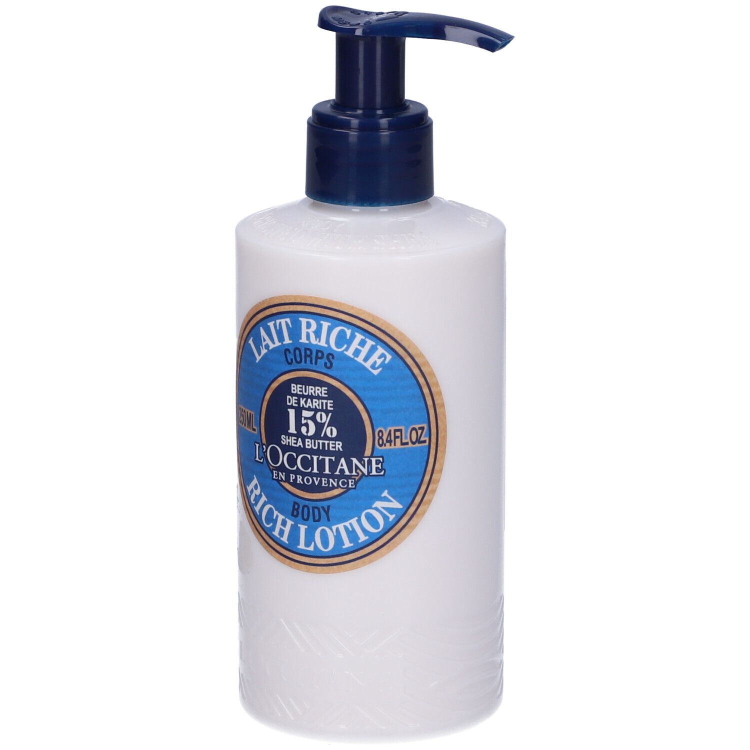 Flacone bianco con erogatore blu. Etichetta: Lait Riche Corps, Burro di Karité 15%, L'Occitane.