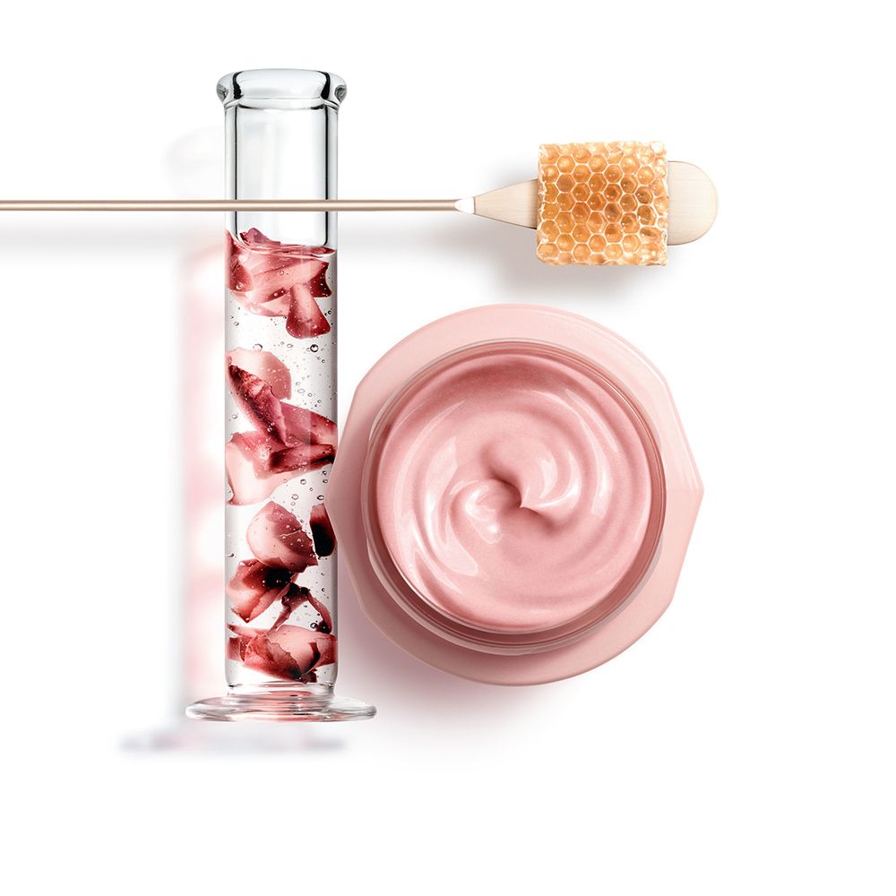 Provette con petali rossi, accanto un vasetto di crema rosa e un applicatore a nido d'ape.