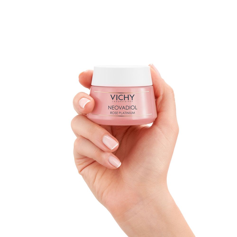 Mano che tiene un vasetto di crema rosa con coperchio bianco. Scritta: Vichy, Neovadiol Rose Platinum.