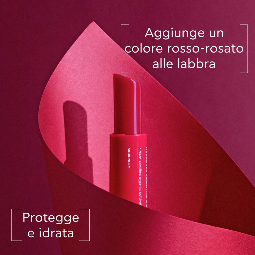 Rossetto rosso, parzialmente fuori dalla confezione. Testo: Aggiunge un colore rosa-rosso alle labbra. Protegge e idrata.