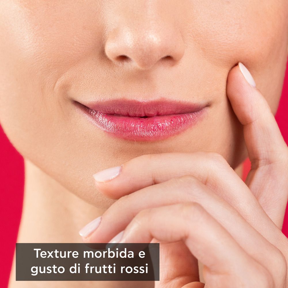 Primo piano di un viso con rossetto. Testo: Texture morbida e gusto di frutti rossi.