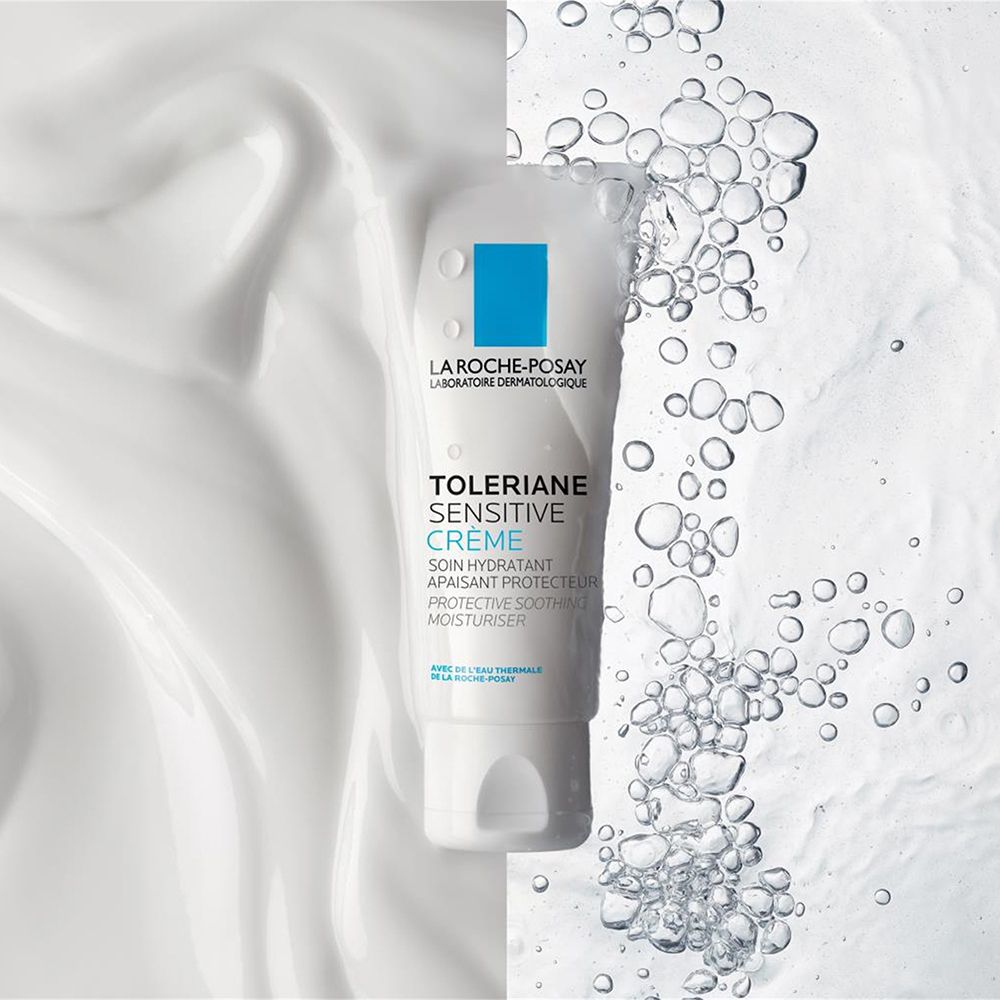 Tube blanc La Roche-Posay Toleriane Sensitive Crème, entouré d'effets crème blanche et bulles d'eau.