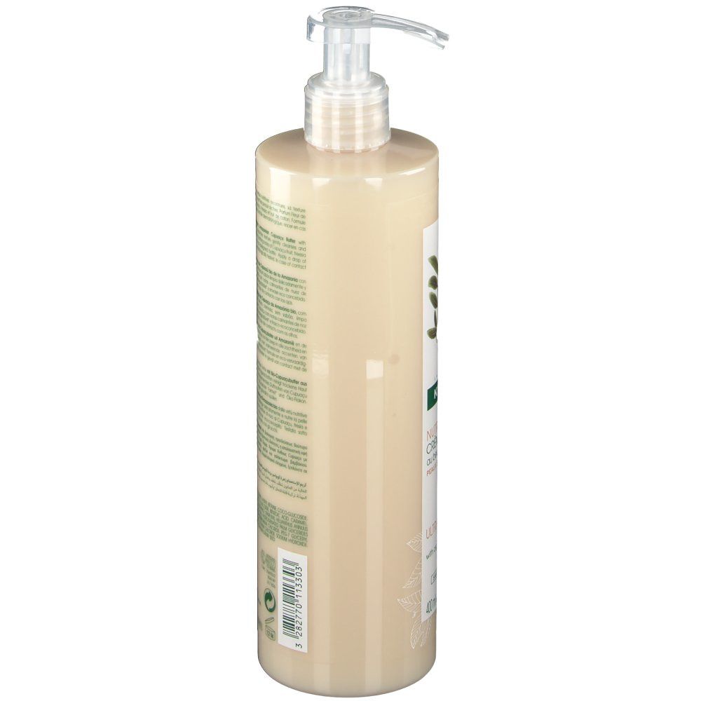 Klorane Duschcreme, Seitenansicht. Flasche mit Pumpe. Etikett mit Produktinformationen. Beige Flüssigkeit.