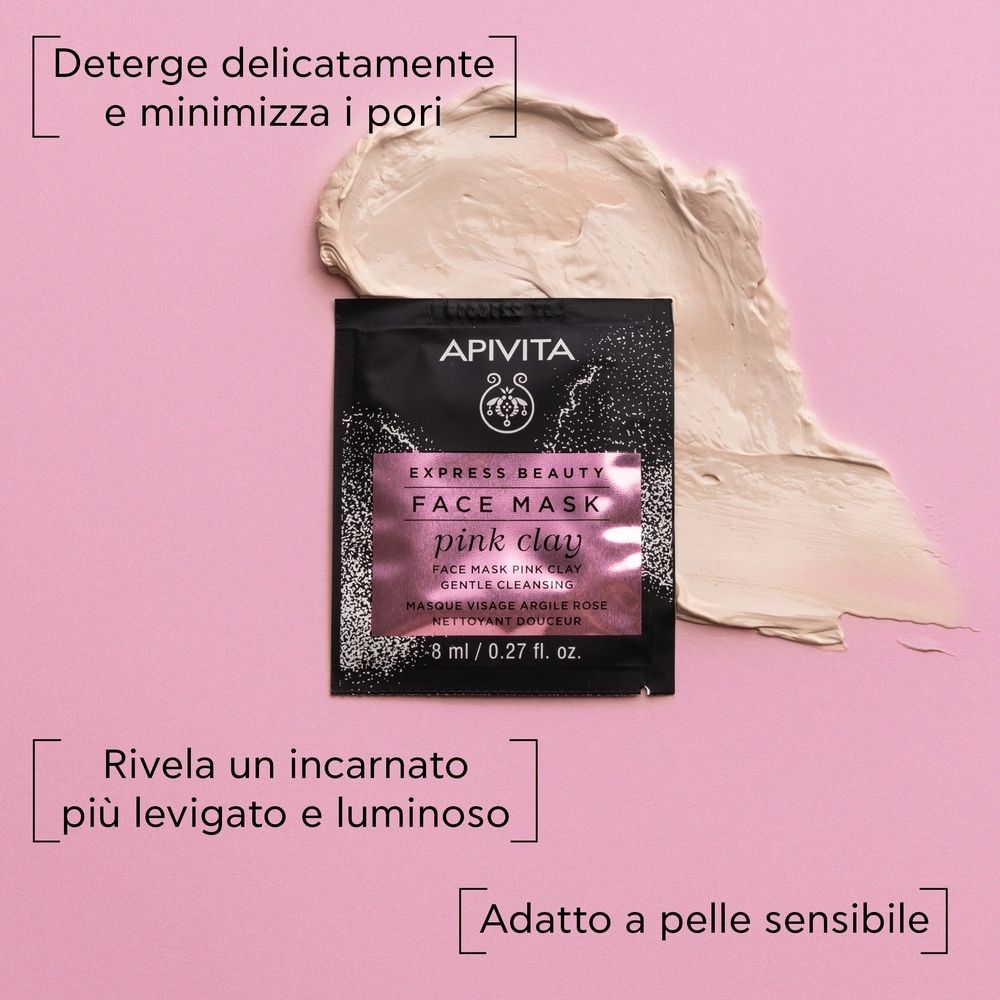 Rosa Hintergrund. Ein Beutel mit APIVITA EXPRESS BEAUTY FACE MASK pink clay. Daneben ein Klecks Gesichtsmaske.