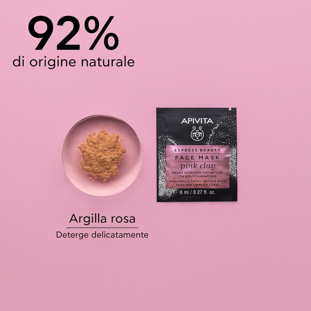 Rosa Hintergrund. Ein Beutel mit APIVITA EXPRESS BEAUTY FACE MASK pink clay. Daneben rosa Pulver in einer Schale.
