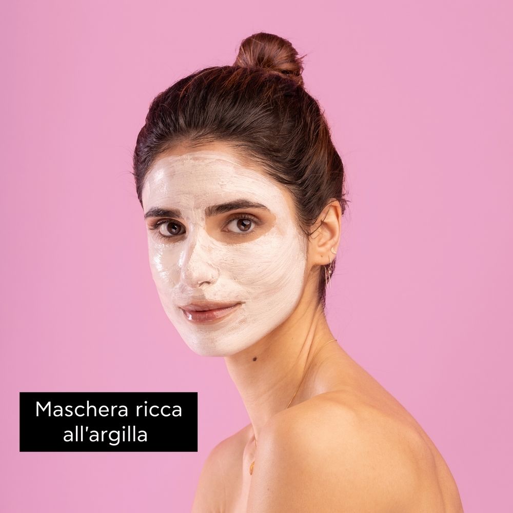 Frau mit Gesichtsmaske. Rosa Hintergrund. Aufschrift: Maschera ricca all'argilla.