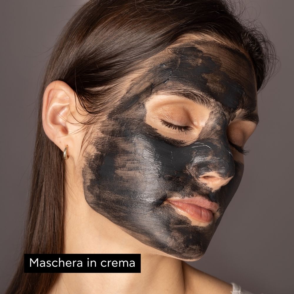 Frau mit schwarzer Gesichtsmaske. Text: Maschera in crema.
