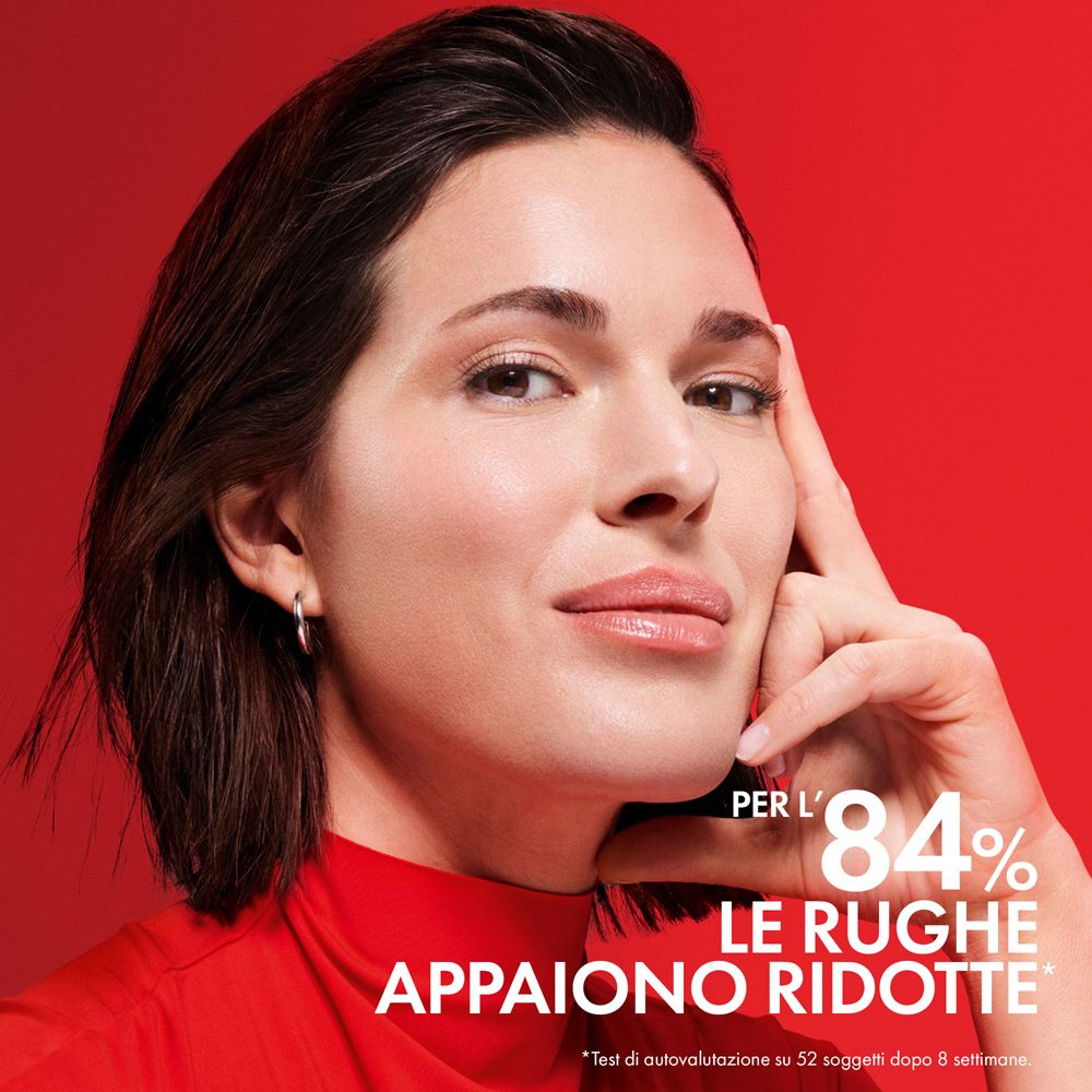 Donna, mano sul mento. Testo: Per l'84% le rughe appaiono ridotte. Sfondo rosso.