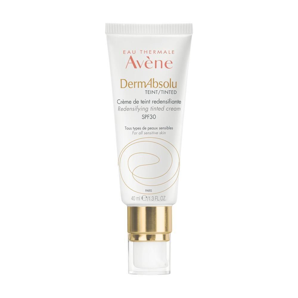 Tube Avène DermAbsolu Crème teintée SPF 30. Blanche, bouchon doré. Texte: DermAbsolu, teinté, SPF 30. Pour peaux sensibles.