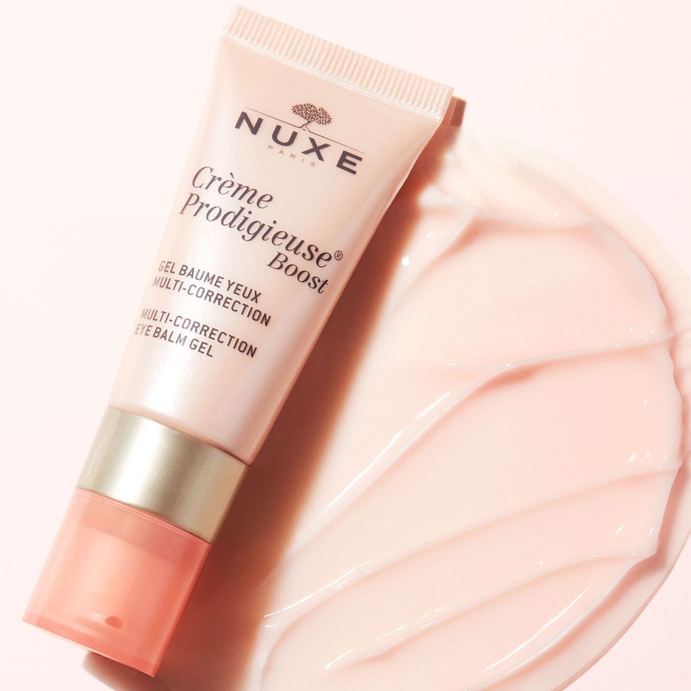 Tube rose de gel baume yeux et produit sur fond. Inscription: NUXE, Crème Prodigieuse Boost.