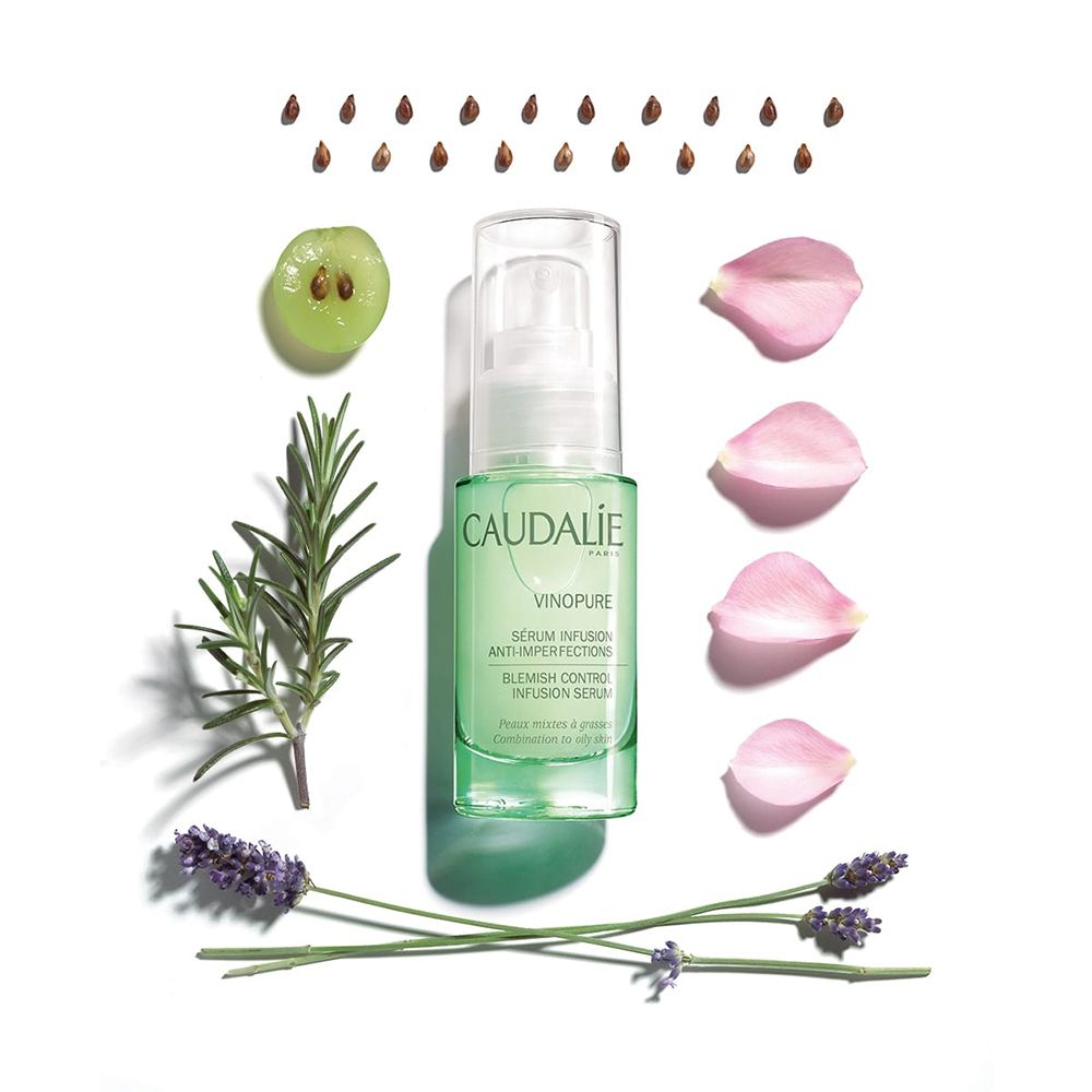 Flacone verde con erogatore, circondato da uva, petali di rosa, rosmarino e lavanda. Scritte CAUDALIE, VINOPURE.